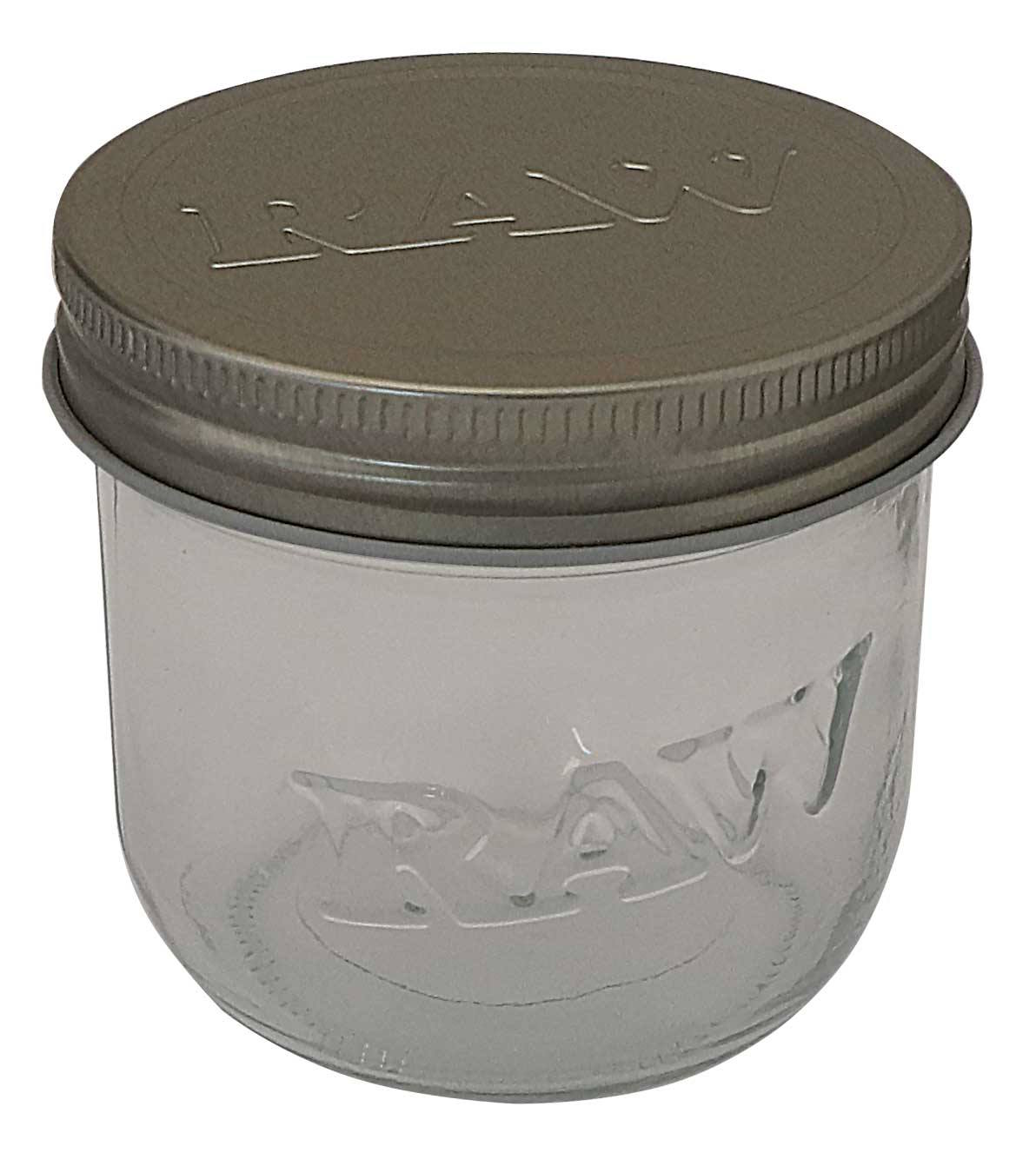 🏺 RAW Mason Glass Jar (10 oz)Das RAW Mason Glass Jar (10 oz) ist die größere Variante der RAW Aufbewahrungsgläser im klassischen Design und bietet mehr Kapazität bei gleicher hochwertiger Materialqualität.Eigenschaften im ÜberblickDesign: Traditionelles, rundes Mason-Jar-Design – bekannt für seine Stabilität und Zuverlässigkeit.Material:Behälter: Gefertigt aus klarem, transparentem Glas, das hygienisch und geruchsneutral ist.Deckel: Aus robustem Aluminium gefertigter Schraubdeckel in silberner Farbe.Größe und Kapazität:Fassungsvermögen: Für 10 oz Inhalt (Ounces), was einem Gewicht von ca. $285\text{ g}$ entspricht.Maße: Mit einem Durchmesser von ca. $\text{ø } 90\text{ mm}$ und einer Höhe von ca. $82\text{ mm}$ ist dieses Glas höher als die 6-oz-Version, behält aber den gleichen Stellflächen-Durchmesser.Verwendung: Ideal zur frischen und diskreten Lagerung von größeren Mengen Kräutern oder trockenen Materialien. Der Schraubverschluss sorgt für einen festen Sitz, der den Inhalt vor Luft und Feuchtigkeit schützt.VorteileVergrößerte Kapazität: Bietet fast doppelt so viel Volumen wie das 6-oz-Glas.Hygienisch und Geruchsneutral: Glas gewährleistet, dass der Geschmack und das Aroma des Inhalts unverfälscht bleiben.Zuverlässiger Verschluss: Der Aluminium-Schraubdeckel sichert den Inhalt zuverlässig.Das RAW Mason Glass Jar (10 oz) ist die perfekte Wahl für alle, die eine größere, langlebige und bewährte Aufbewahrungslösung im authentischen RAW-Stil benötigen.